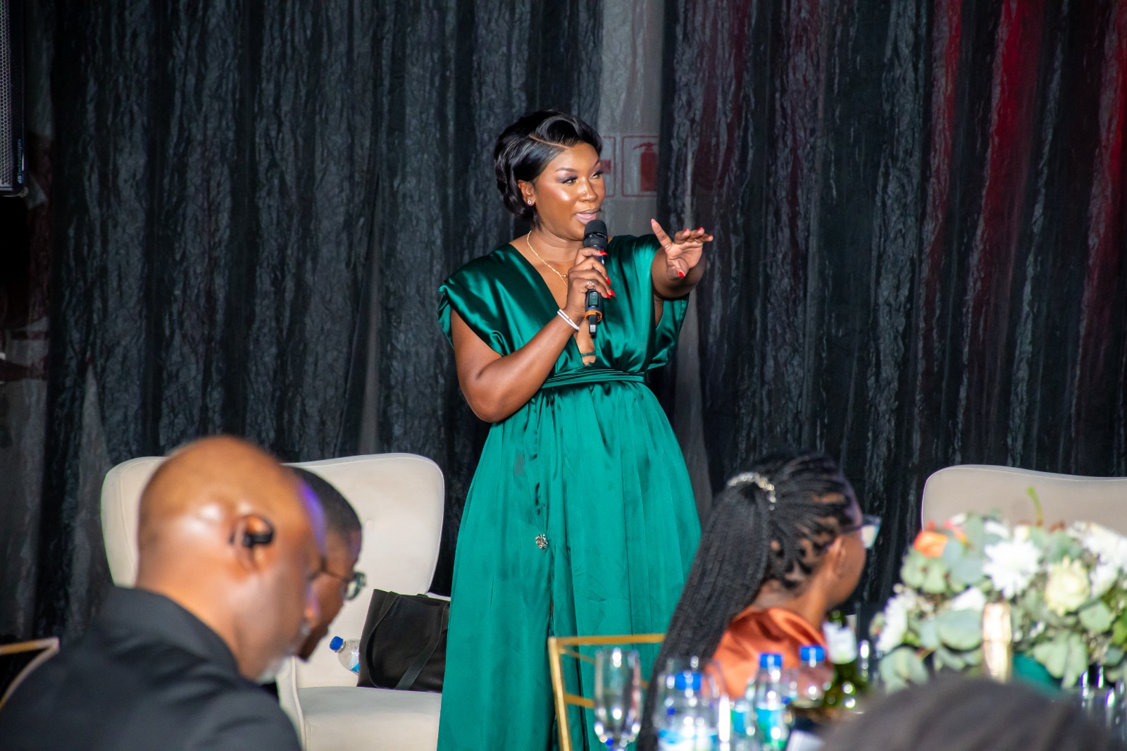 Lorraine Kondombolo engaging guests while hosting a formal dinner