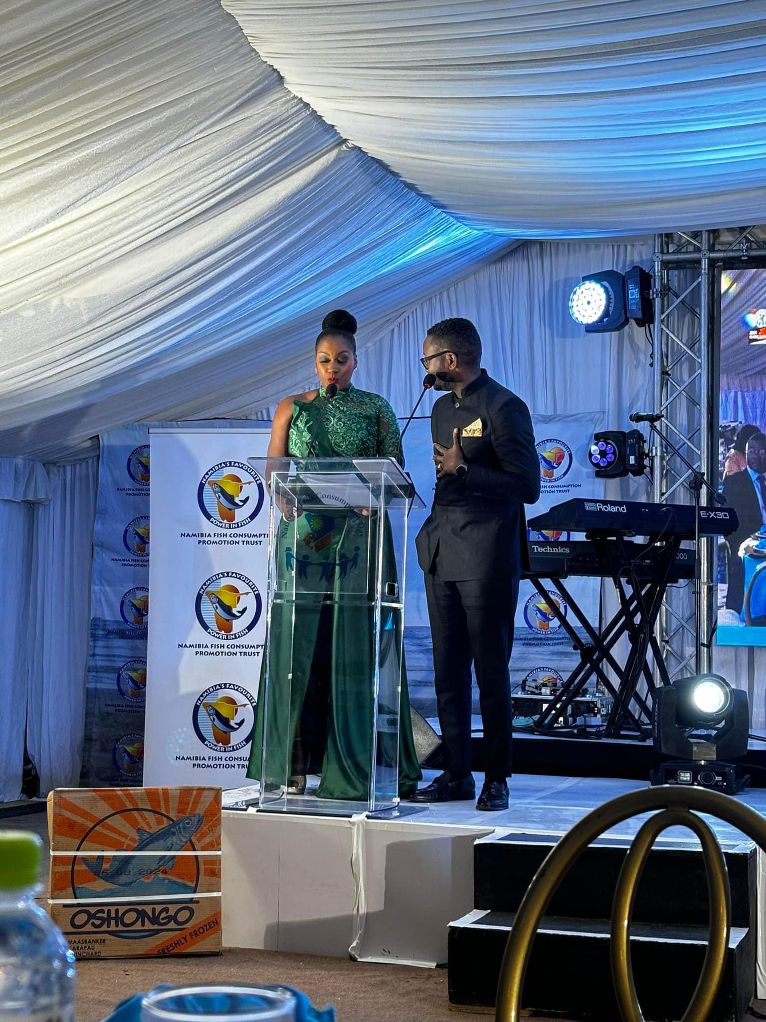 Lorraine Kondombolo co-hosting a gala programme at a lectern