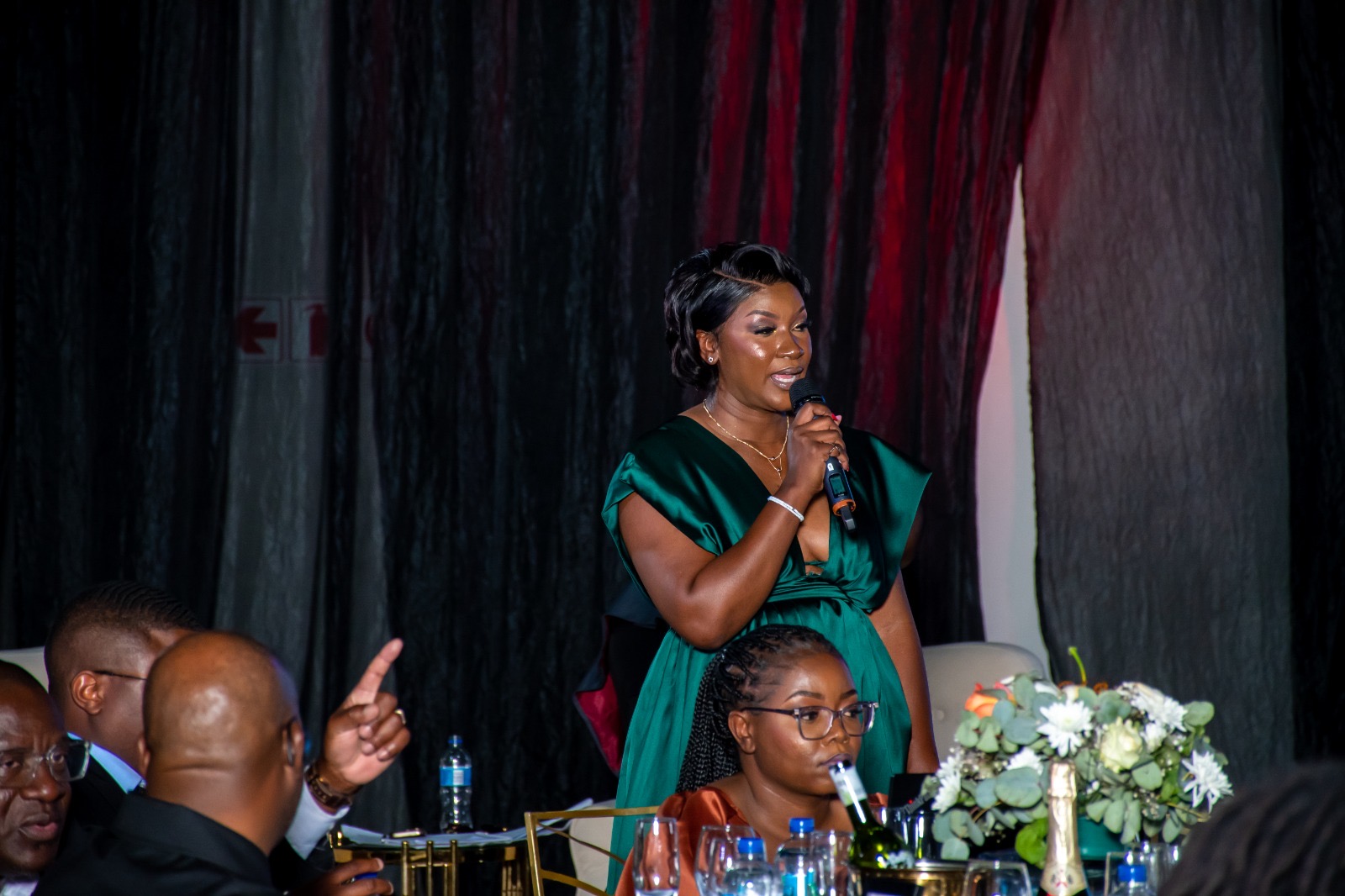 Lorraine Kondombolo addressing guests at a formal dinner